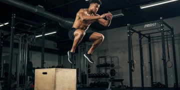 Explosive Power Training: 3-Month Protocol for 2025 Athlete performing a powerful box jump, demonstrating explosive power and agility in a gym.